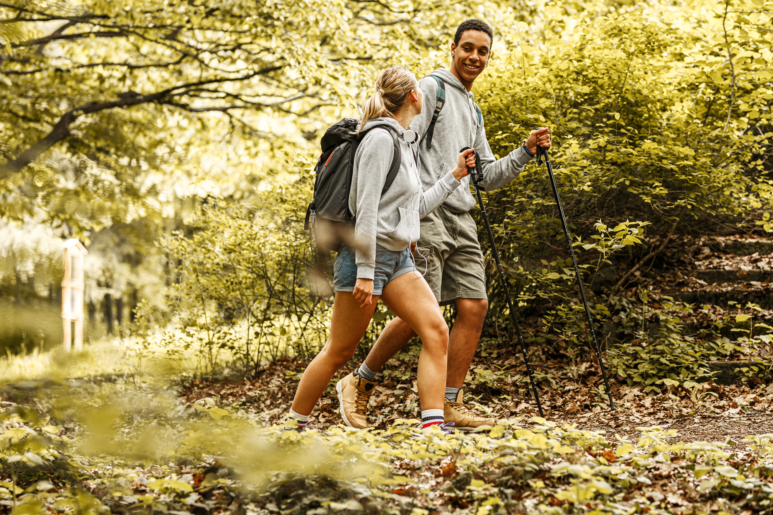 Young couple hiking trough forest.